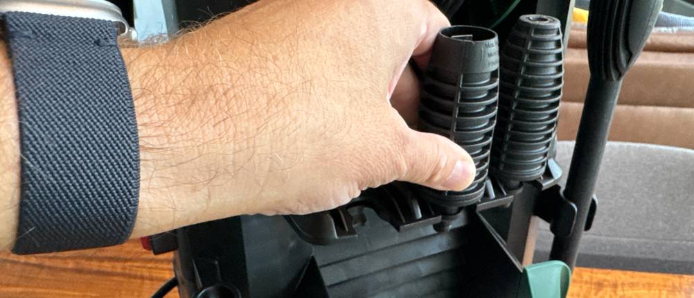 Eine Hand steckt eine Düse an den Bosch AdvancedAquatak 140