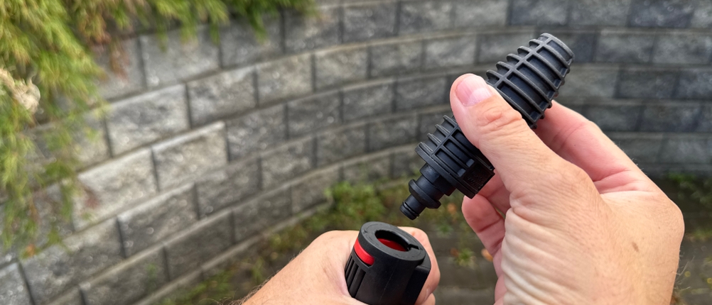 Eine Hand steckt eine Düse auf den Bosch AdvancedAquatak 140