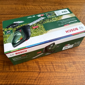 Der Karton der Bosch AdvancedShear 18V-10 liegt auf einem Tisch.