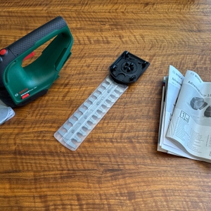 Der Lieferumfang der Bosch AdvancedShear 18V-10 liegt auf einem Tisch.