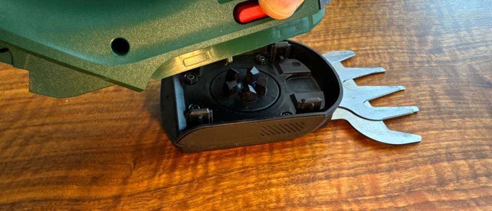 Eine Hand löst den Aufsatz der Bosch AdvancedShear 18V-10.