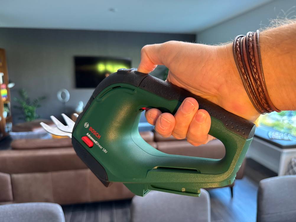 Eine Hand hält die Bosch AdvancedShear 18V-10 fest.