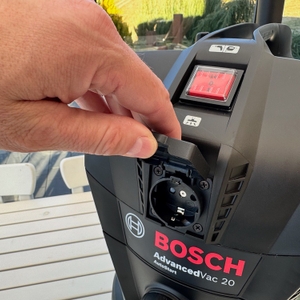 Eine Hand öffnet die Steckdose des Bosch AdvancedVac 20