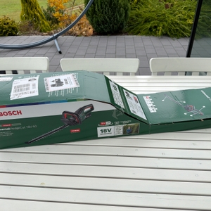 Der Karton der Bosch-Akku-Heckenschere ‎0600849K01 liegt auf einem Tisch