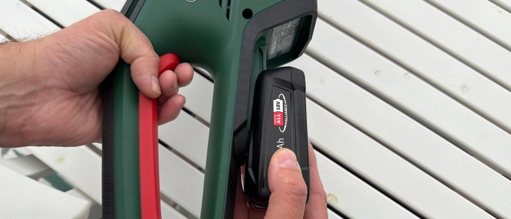 Der Akku wird auf die Bosch-Akku-Heckenschere ‎0600849K01 geschoben