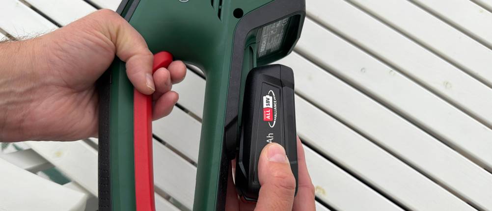 Der Akku wird auf die Bosch-Akku-Heckenschere ‎0600849K01 geschoben