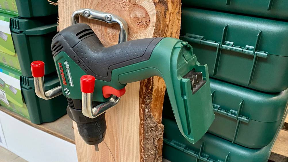 Nahaufnahme der Akkuaufnahme eines Bosch-Akku-Schlagbohrschraubers im Test der an der Wand hängt.