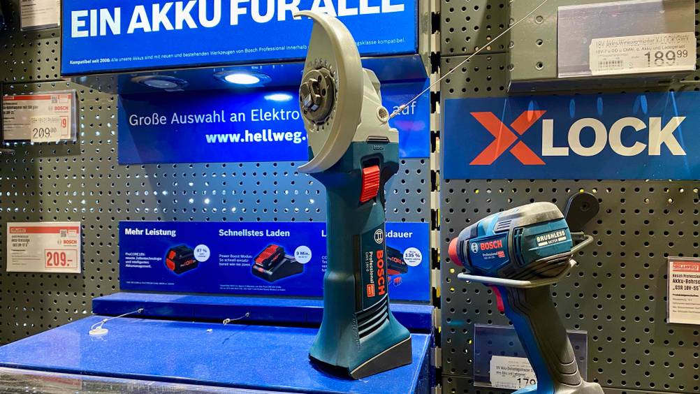 Bosch-Akku-Winkelschleifer getestet: Ein Gerät in einer Verkaufsfläche neben anderen Produkten auf einem blauen Regal stehend.