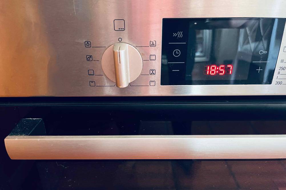Backofen-Test: Detailansicht der Anzeige mit Uhrzeit und des Funktionsreglers sowie des Backofentür-Griffs.