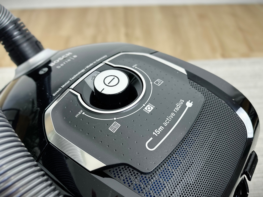 Das Bild zeigt den Bosch BGL8XALL Staubsauger in Nahaufnahme. Der Fokus liegt auf dem oberen Bereich mit Bedienfeld und Schlauchanschluss.