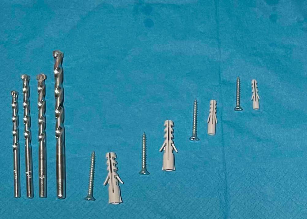 Dübel, Schrauben und vier Bohrer, die zu einem getesteten Bosch-Bohrer-Set gehören.