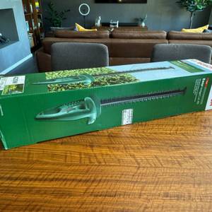 Der Karton der Bosch Easy Hedge Cut 45 liegt auf einem Tisch.