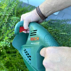 Zwei Hände halten die Bosch Easy Hedge Cut 45 während der Anwendung fest.