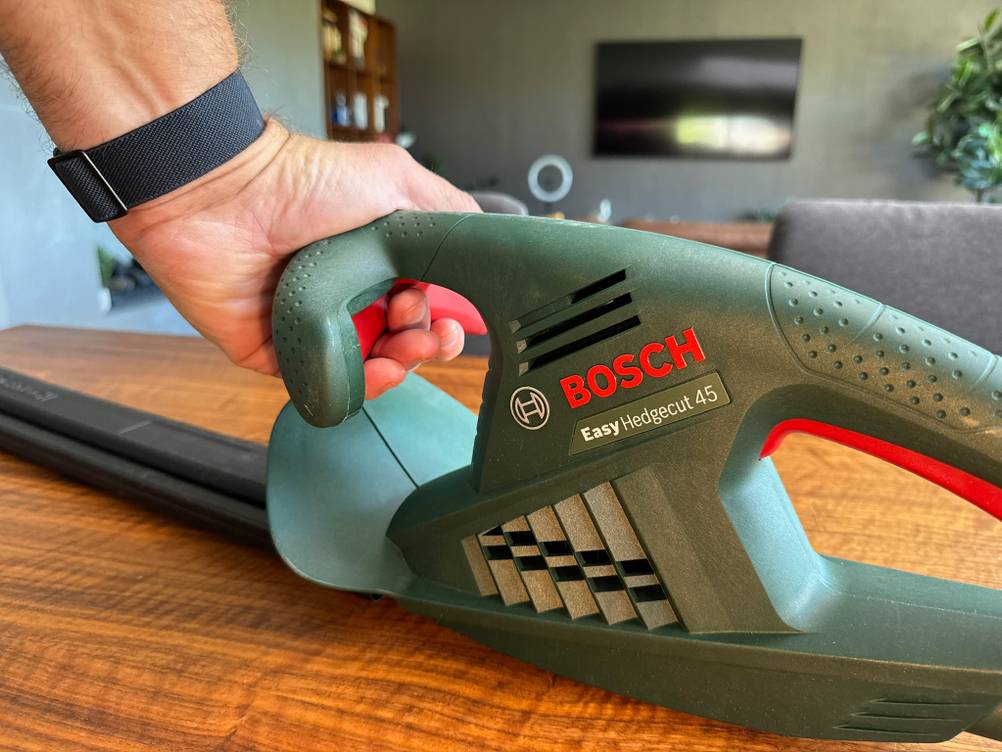 Eine Hand bedient den vorderen Griff der Bosch Easy Hedge Cut 45