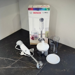 Stabmixer im Test: Der Bosch ErgoMix steht zusammen mit dem Zubehör und der Verpackung auf einer Arbeitsfläche..