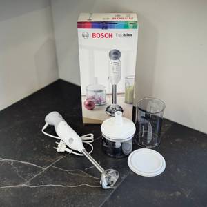 Stabmixer im Test: Der Bosch ErgoMix steht zusammen mit dem Zubehör und der Verpackung auf einer Arbeitsfläche..