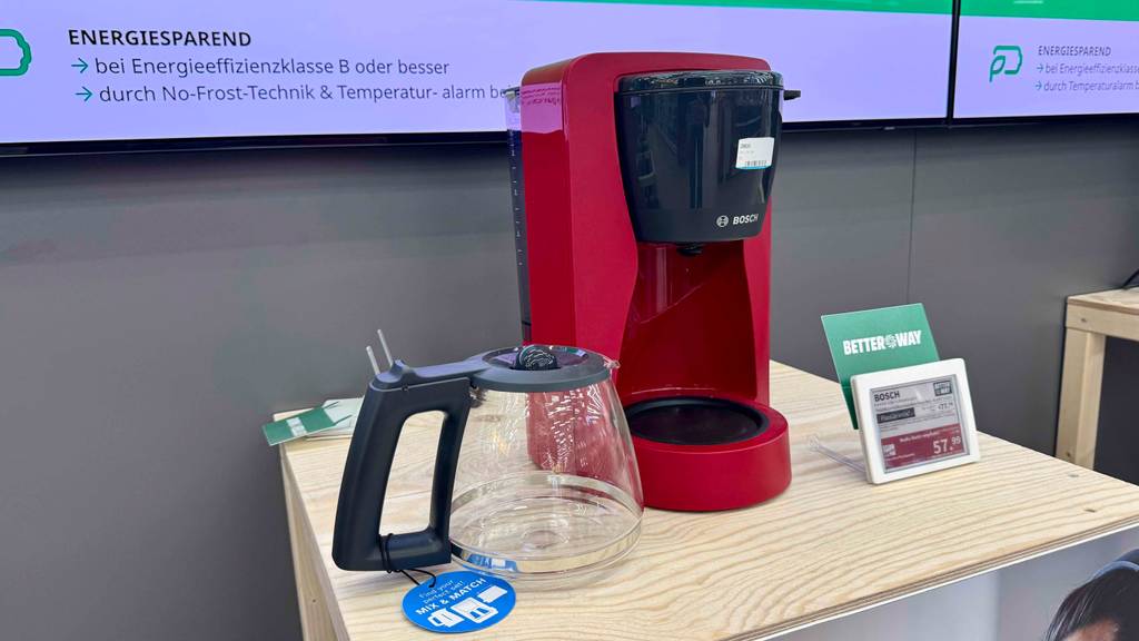 Im Test: Eine rote Bosch-Kaffeemaschine steht auf einem hellen Holztisch.