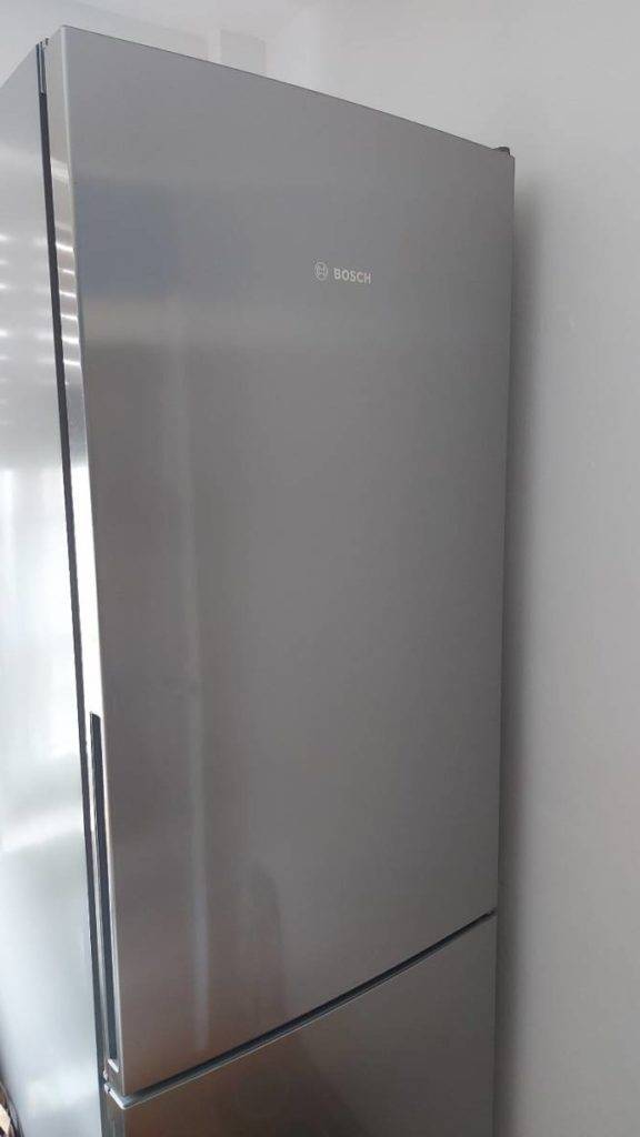 Kühl-Gefrierkombination-Test: Nahaufnahme eines geschlossenen Modells der Marke Bosch in Silber vor weißer Wand.