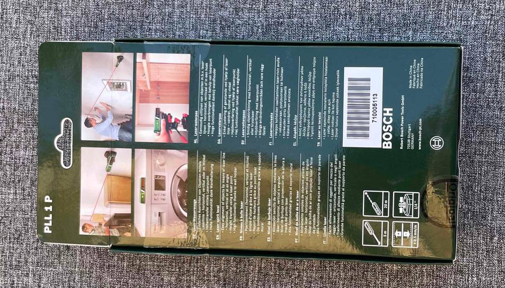 Rückseite der Verpackung einer getesteten Laser-Wasserwaage auf einer grauen Stofffläche.