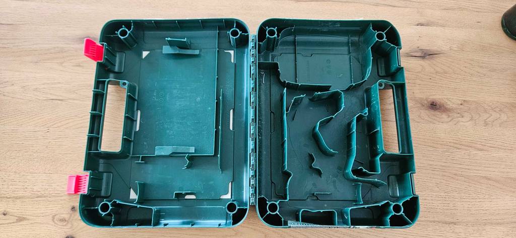 Getesteter Bosch Akkuschrauber: der leere Aufbewahrungskoffer liegt offen auf einem Boden.