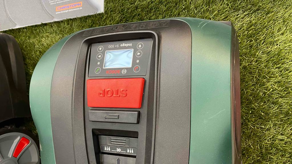Mähroboter im Test: Roboter hat eine grüne Farbe, mit roten und schwarzen Details.