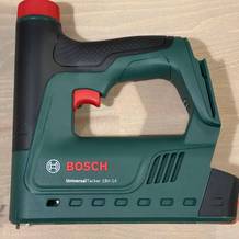 Der Bosch UniversalTacker 18V‑14 liegt frei auf einer Holzoberfläche. Das Gehäuse wirkt robust, der Griff ist ergonomisch geformt.