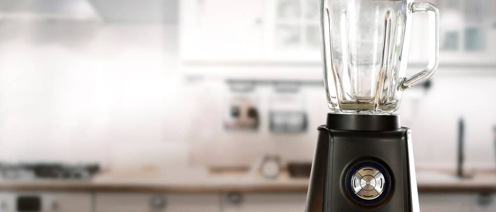 Bosch-Mixer im Test: Ein schwarzer Standmixer mit einem Drehregler aus Edelstahl steht in einer Küche auf einer Holzablage.