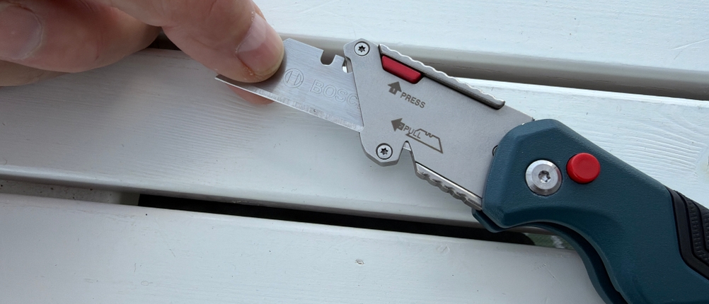 Eine Hand zieht die Klinge aus dem Bosch Professional 1600A016BL