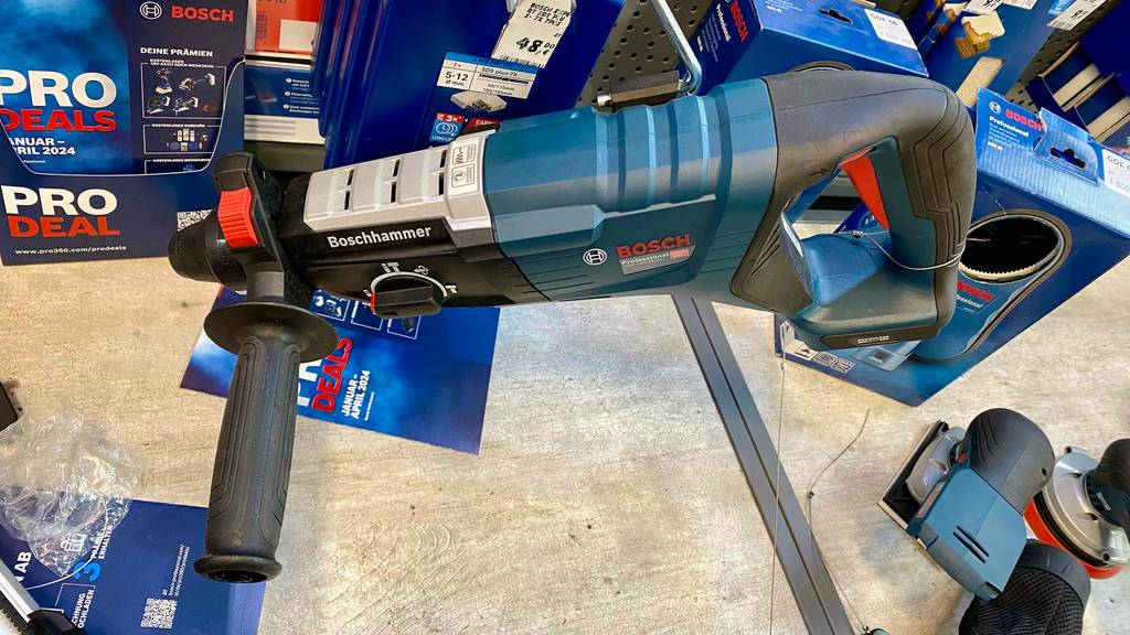 Ein getesteter Bosch Professional Bohrhammer, von oben betrachtet, liegt auf einem hellen Regal.