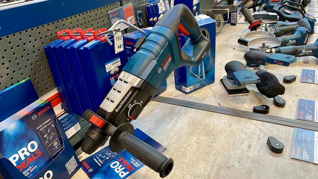 Ein Bosch Professional Bohrhammer von vorn betrachtet liegt zum testen zwischen einigen anderen Geräten.