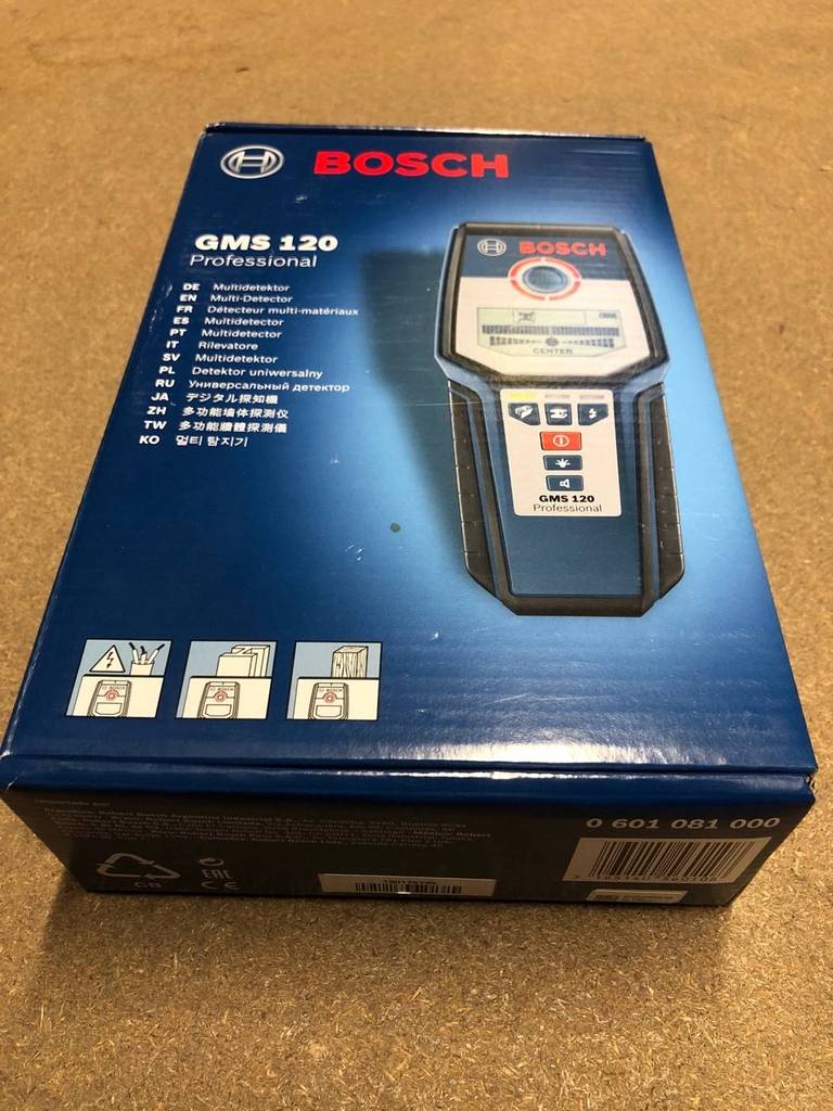 Leitungssucher-Test: Nahaufnahme des blauen geschlossenen Verpackungskartons auf brauner Fläche von einem Bosch Professional digitalen Ortungsgerät GMS 120.