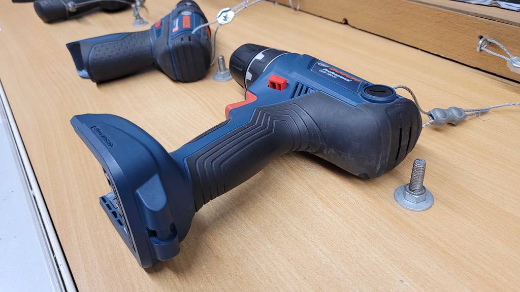 ein auf einem Ausstellungsregal liegender, getesteter Profi-Akkuschrauber mit 18 Volt Kapazität.