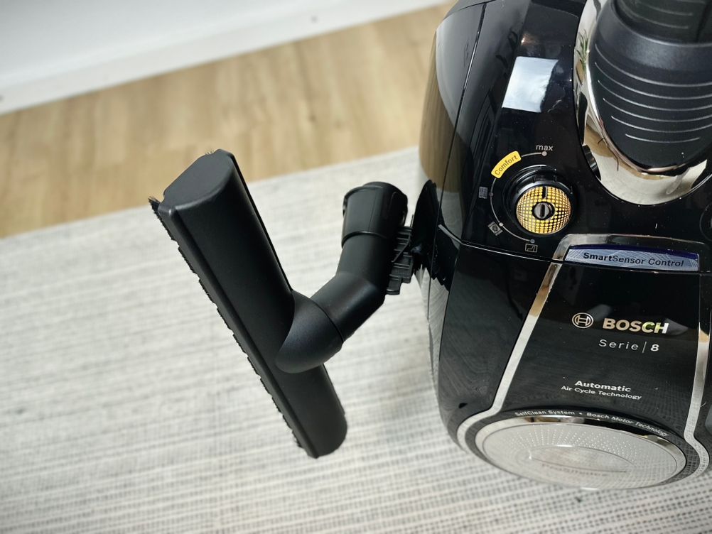 Der Bosch ProSilence Serie 8 BGS7MS64 ist aus der Nähe mit montierter Bodendüse und Saugrohr zu sehen. Der Fokus liegt auf dem Bedienfeld und dem Schlauchanschluss.