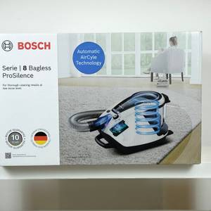 Die Vorderseite der Verpackung des Bosch ProSilence Serie 8 BGS7MS64 zeigt das Gerät in Wohnumgebung.