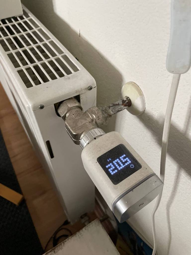 Getestetes Smart-Home-Thermostat mit Sicht auf das integrierte eingeschaltete Display ist an einem Heizkörper befestigt.