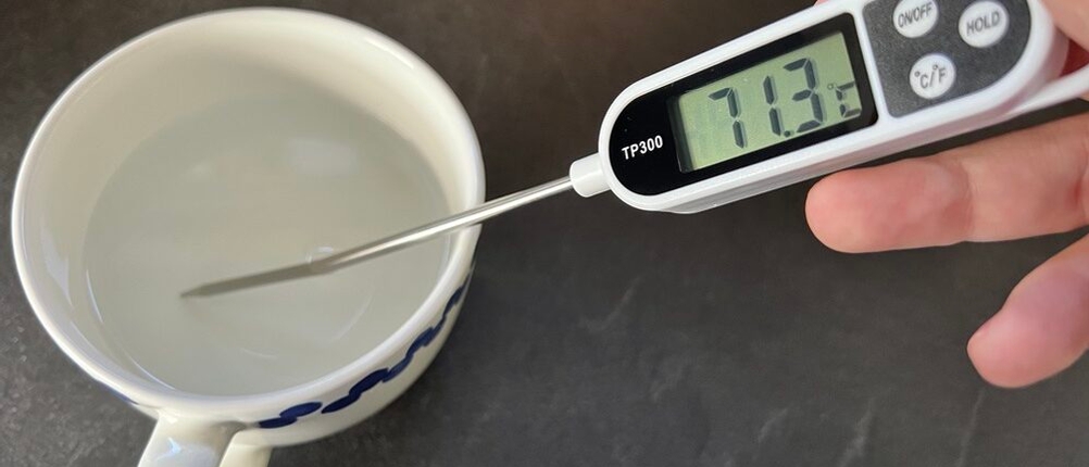 Temperaturmesser in Tasse, heißes Wasser