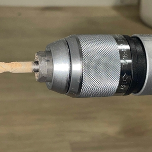 Nahaufnahme des eingespannten Bohrers der Bosch GSB 21-2 RCT während einer aktiven Bohrung.