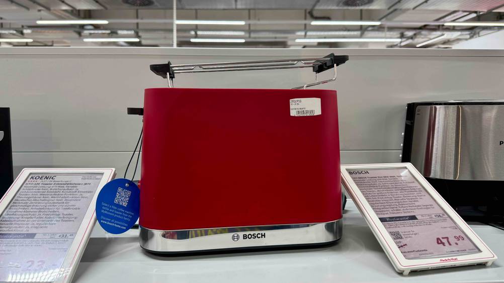 Ein getesteter Bosch-Toaster von vorne in einem Verkaufsregal, danenben Preisangaben.