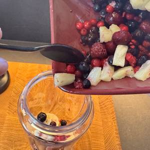 Beeren und kleingeschnittenes Obst werden in den Smoothie-Maker gefüllt.