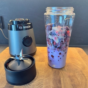Beeren und Milch befinden sich im Smoothie-Maker, bereit zum Mixen.