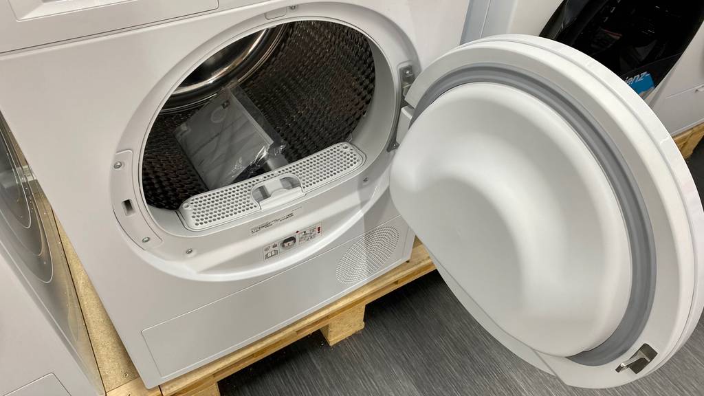 Wärmepumpentrockner-8-kg im Test mit geöffneter Tür und Blick auf das Flusen-Fach und die Edelstahl-Trommel.