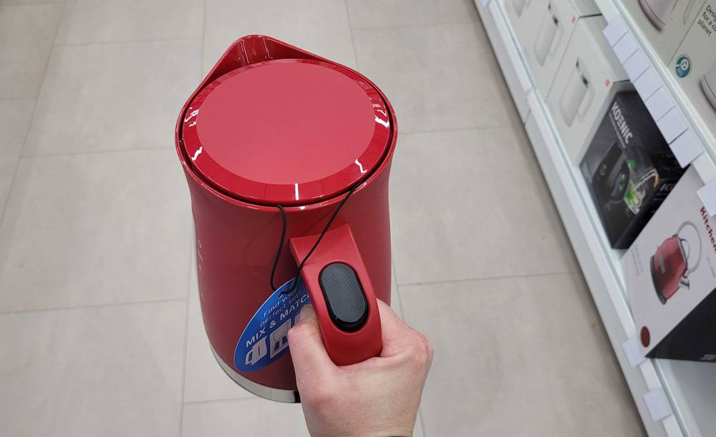 Eine Hand hält einen getesteten Bosch-Wasserkocher hoch.