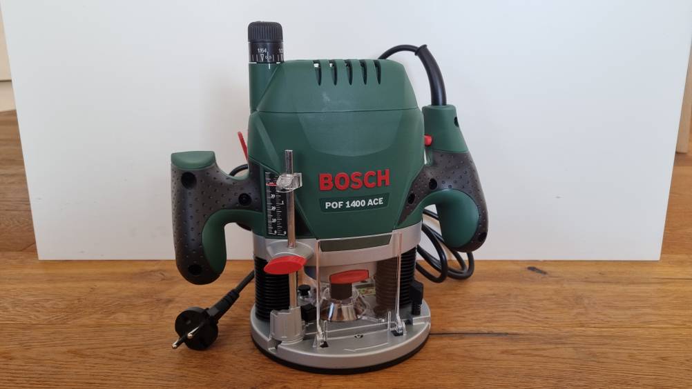 Oberfräse im Test: Bosch POF 1400 ACE steht auf dem Boden vor einer weißen Wand