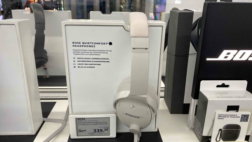 Ein Bose Kopfhörer im Test hängt über dem Infoständer.