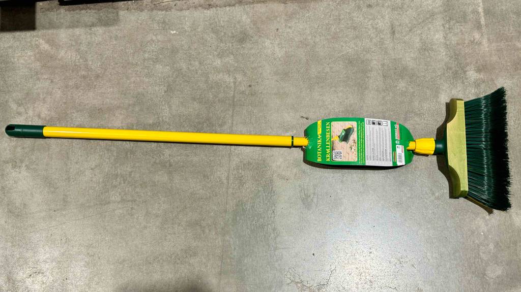 Ein Krallenbesen liegt zum Testen auf einem Betonboden.