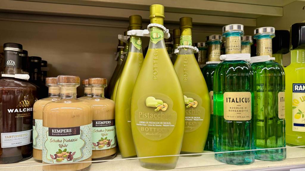 Im Test: Pistazienlikör in der bauchigen Flasche befindet sich neben weiteren Likören in einem Verkaufsregal.
