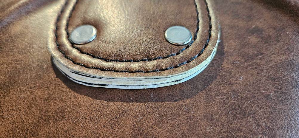 Nahaufnahme der Verarbeitung des Leders und der Nieten eines getesteten Boxsacks.