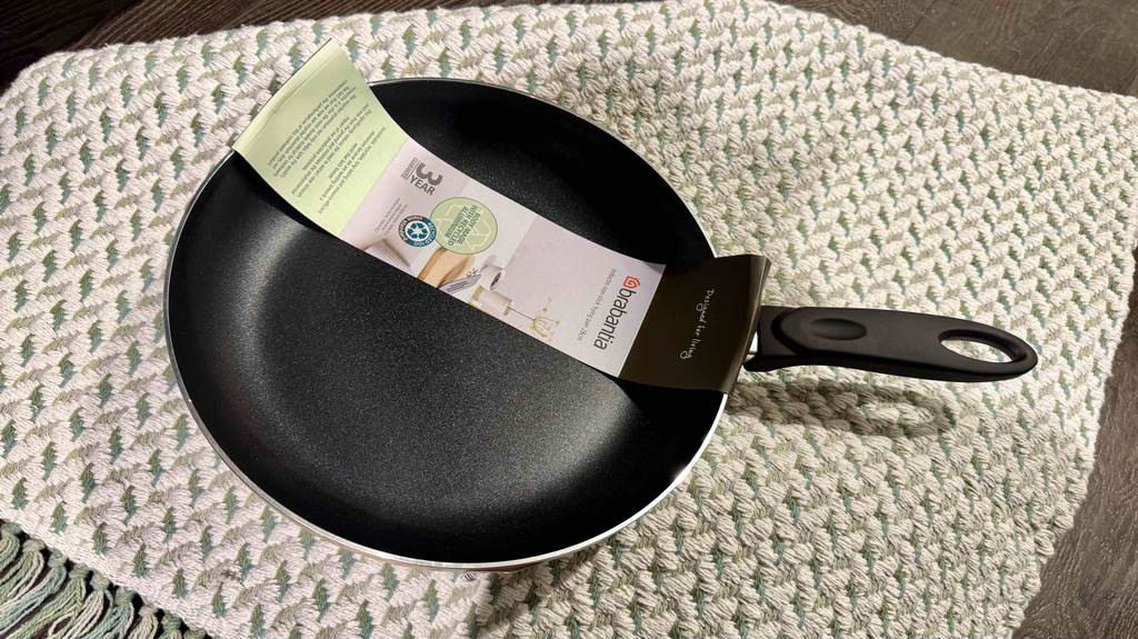 Im Test: Eine Pfanne mit 28 cm Durchmesser liegt inklusive Banderole auf einem Küchenläufer.