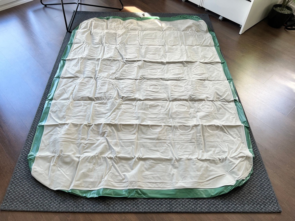 Die vollständig entfaltete, nicht aufgepumpte Brace Master USAAL462201 liegt auf einem Teppich.