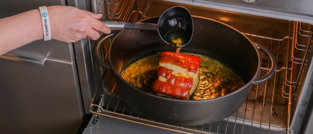 Bräter im Test: Bräter im Backofen, der mit einem Braten befüllt ist und mit Garflüssigkeit übergossen wird